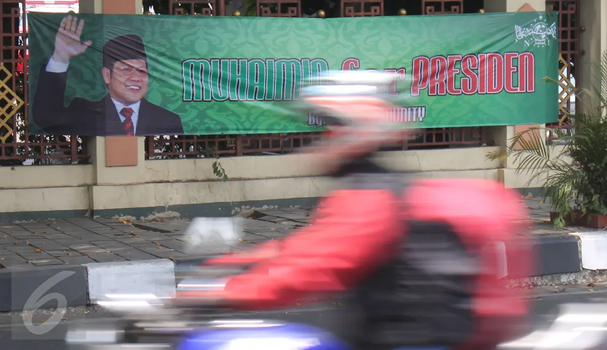 Pengendara motor melintasi spanduk bertuliskan 'Muhaimin for President' di pagar Masjid Sunda Kelapa, Jakarta, Sabtu (12/9). Pemasangan spanduk itu melanggar UU tentang larangan penggunaan tempat ibadah sebagai tempat kampanye. (Liputan6.com/Angga Yuniar)