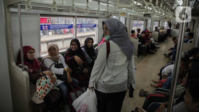 Penumpang KRL Commuter Line Bogor-Jakarta berjalan dalam kereta di Stasiun Tanah Abang, Jakarta, Minggu (29/12/2019). PT KCI menambah 28 perjalanan KRL tambahan khusus perayaan pergantian tahun. (Liputan6.com/Faizal Fanani)