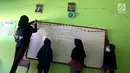 Sejumlah siswi memasang papan tulis yang jatuh akibat gempa di dalam kelas SMP Negeri 6 Palu, Sulawesi Tengah, Senin (8/10). Hari pertama sekolah pascagempa dan tsunami Palu, siswa belum memulai aktivitas belajar mengajar. (Liputan6.com/Fery Pradolo)
