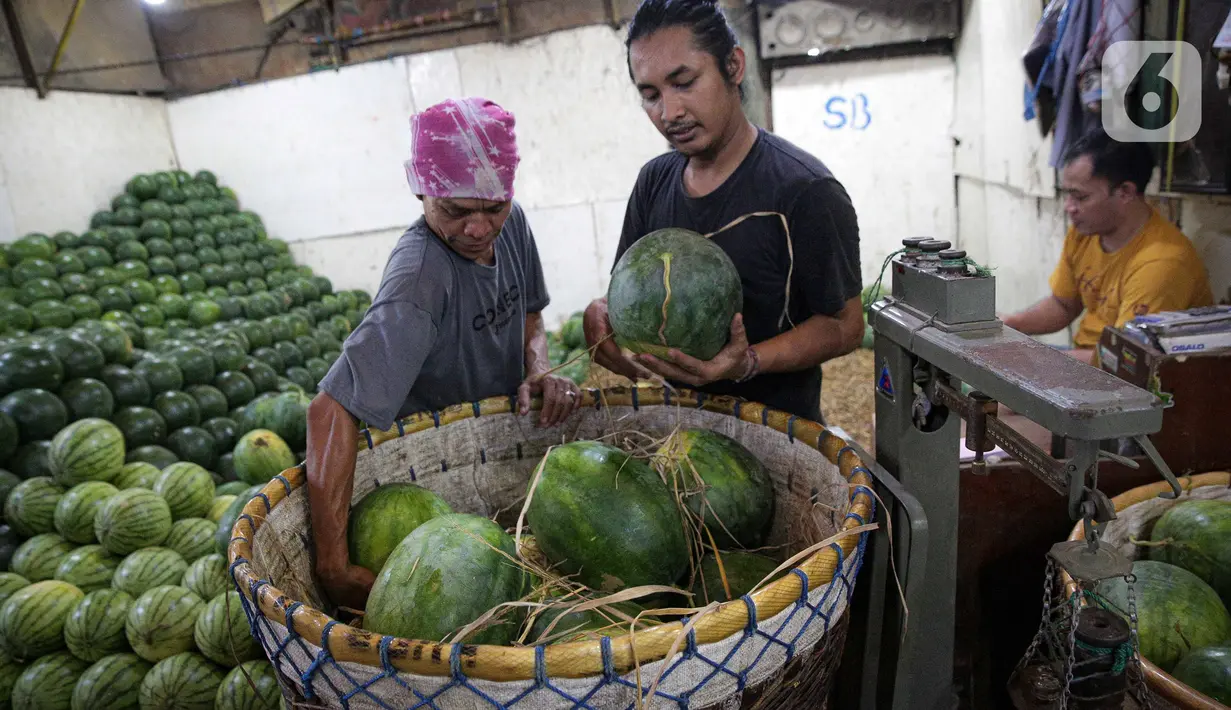 Pedagang menata semangka di Pasar Induk Sayur Buah Kramat Jati, Jakarta, Selasa (5/4/2022). Memasuki bulan suci Ramadhan, permintaan buah-buahan mengalami peningkatan untuk diolah menjadi menu berbuka puasa. (Liputan6.com/Faizal Fanani)