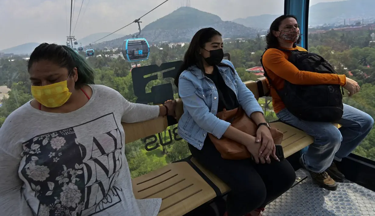 Penumpang melakukan perjalanan dengan sistem kereta gantung yang dijuluki Cablebus setelah peresmiannya di pinggiran Mexico City, Meksiko, 12 Juli 2021. Mexico City mulai mengoperasikan sistem kereta gantung yang menjanjikan untuk menghemat waktu bagi ribuan pengguna. (PEDRO PARDO/AFP)