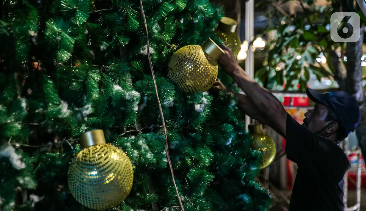 Pekerja memasang ornamen pohon Natal di Thamrin 10, Jakarta, Selasa (22/12/2020). Pohon Natal akan dipasang pada 23 Desember hingga 1 Januari mendatang. (Liputan6.com/Faizal Fanani)