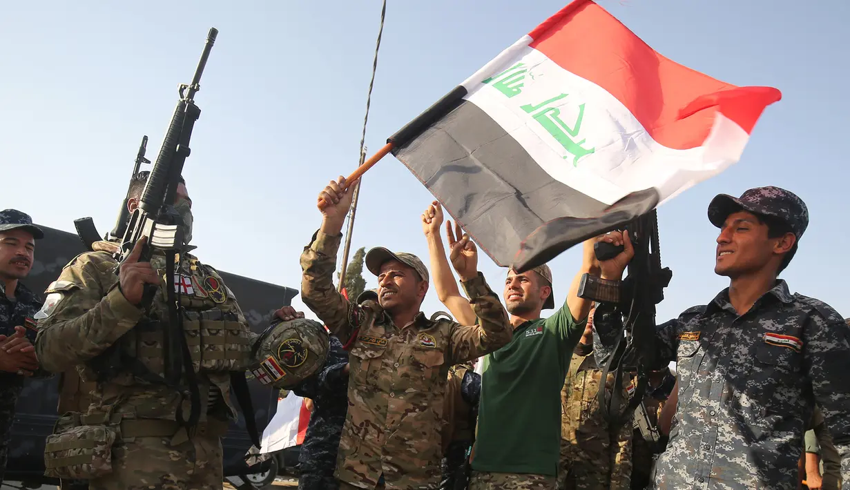 Anggota polisi Federal Irak  merayakan keberhasilan menyingkirkan militan ISIS dari Kota Tua Mosul, Minggu (9/7). Kantor PM Irak Haider al-Abadi mengumumkan kemenangan atas ISIS di kota itu setelah bertempur selama delapan bulan. (AHMAD AL-RUBAYE/AFP)