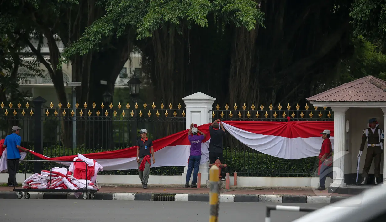 Pekerja memasang kain renda berwarna merah putih dipagar depan Istana Merdeka, Jakarta, Senin (13/4/2015). Jelang Konferensi Asia Afrika (KAA) ke-60 di Bandung pada 24 April mendatang, Istana Merdeka mulai dipercantik. (Liputan6.com/Faizal Fanani)