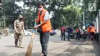 Warga menyapu jalan saat terjaring operasi tertib masker dalam rangka penerapan protokol kesehatan COVID-19 di Jalan Fatmawati, Jakarta, Kamis (10/3/2022). Pelanggar disanksi kerja sosial menyapu jalan atau denda Rp250 ribu dan menandatangani surat pernyataan tak mengulangi.(merdeka.com/Arie Basuki)
