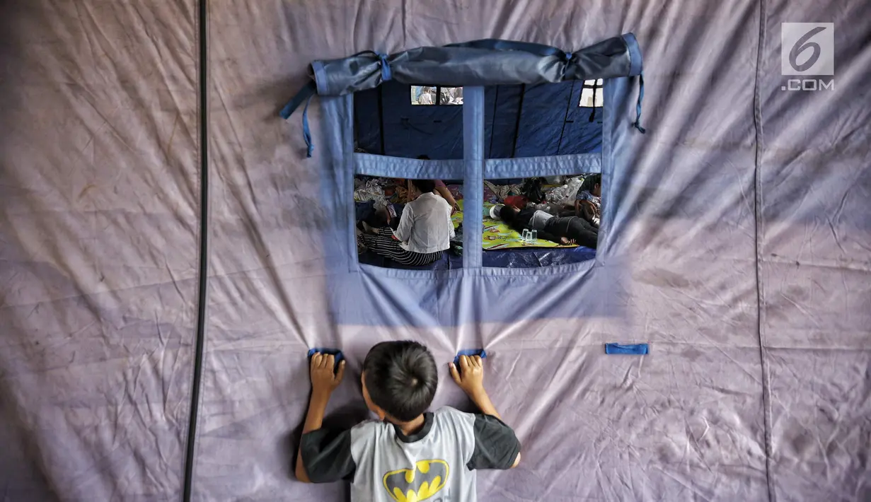 Seorang anak berada di luar tenda paska kebakaran di permukiman kumuh di RW 02 Kampung Walang, Lodan Raya, Jakarta, Minggu (25/8). Sebanyak 420 jiwa saat ini mengungsi pasca-kebakaran, di sebuah tenda darurat. (Liputan6.com/Faizal Fanani)