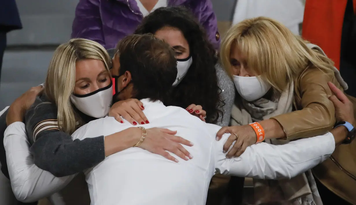 Pettenis Rafael Nadal mencium istri (kiri) dan anggota keluarganya saat merayakan kemenangannya atas Novak Djokovic pada final Prancis Terbuka 2020 di Stadion Roland Garros, Paris, Prancis, Minggu (11/10/2020). Nadal menyamai rekor Roger Federer dengan 20 gelar Grand Slam. (AP Photo/Christophe Ena)