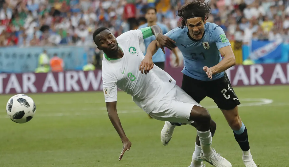 Pemain Uruguay, Edinson Cavani (kanan) berebut bola dengan pemain Arab Saudi, Osama Hawsawi pada laga grup A Piala Dunia 2018 di Rostov Arena, Rostov-on-Don, Rusia, (20/6/2018). Uruguay menang 1-0. (AP/Darko Vojinovic)
