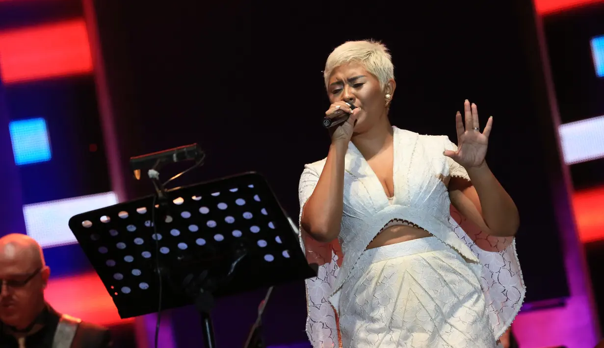 Sebelah kanan dan kiri layar memajang foto Billie Holiday. Suara indah Dira Sugandi mengalun bersama dengan iringan jazz asal Belanda. Malam itu, Dira juga membawakan lagu Billie Holiday, berjudul Good Morning Heartache. (Adrian Putra/Bintang.com)