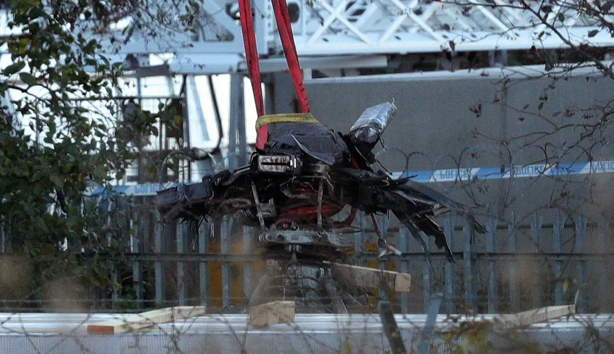 Crane mengevakuasi bangkai helikopter dari lokasi kecelakaan yang menewaskan bos Leicester City Vichai Srivaddhanaprabha di Leicester, Inggris, Kamis (1/11). Vichai ialah pengusaha Thailand yang membeli Leicester City pada 2010. (Aaron Chown/PA via AP)