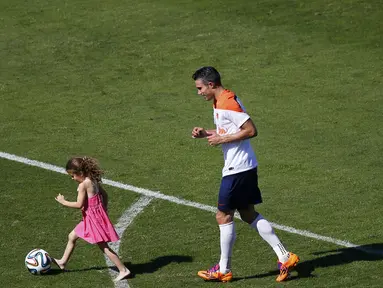 Waktu luang usai menjalani sesi latihan di Rio de Janeiro, (24/6/2014) dimanfaatkan oleh penyerang Timnas Belanda, Robin van Persie, untuk bermain bersama putrinya, Dina. (REUTERS/Ricardo Moraes)