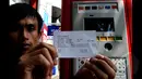 Seorang pengendara sepeda motor menunjukan struck bukti pembayaran parkir dengan menggunakan mesin Terminal Parkir Elektronik, Jakarta, Kamis (29-01-2015).  Sebanyak enam bank terlibat dalam sistem pembayaran ini. (Liputan6.com/Andrian M Tunay)