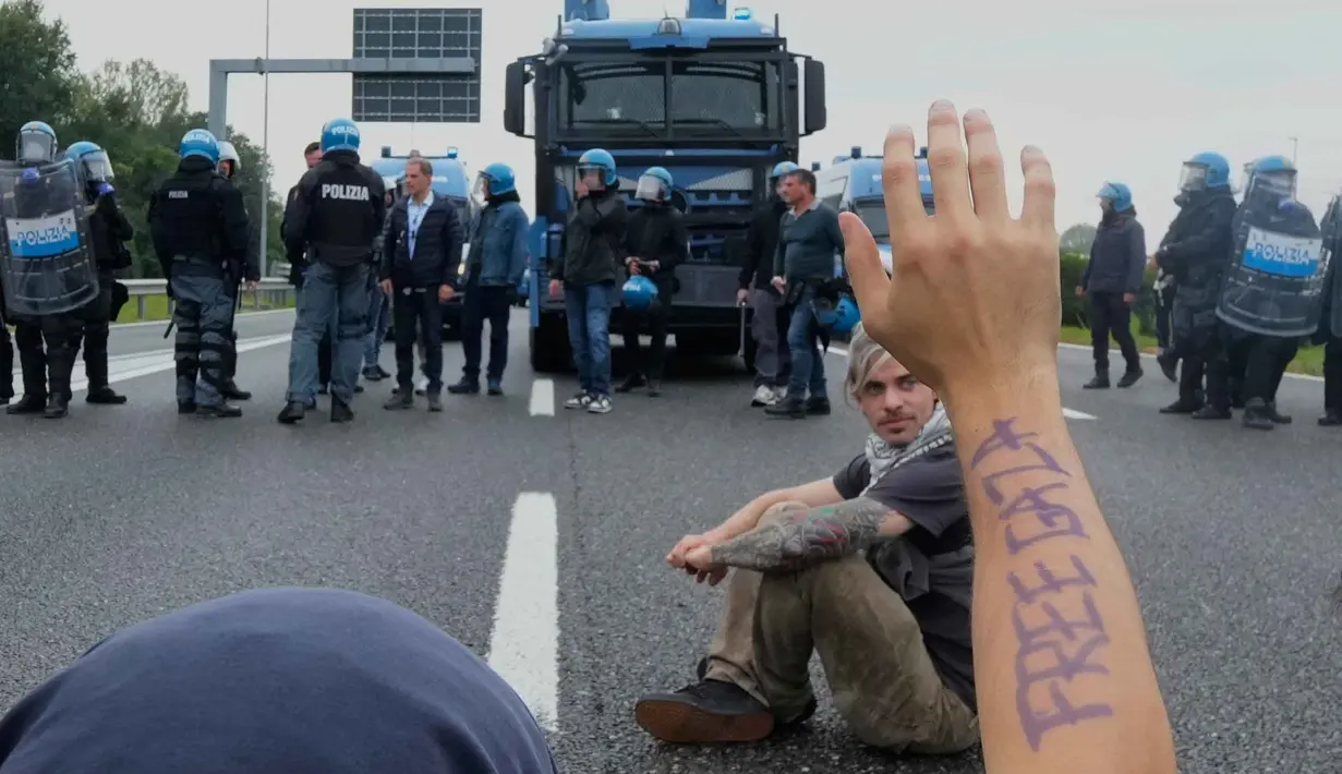 Demonstran pro-Palestina duduk di jalan lingkar Milan dalam aksi protes sebagai bagian dari pemogokan umum nasional yang diserukan oleh berbagai serikat pekerja untuk memprotes situasi di Gaza, di Milan, Italia, Jumat 3 Oktober 2025. (AP Photo/Luca Bruno)