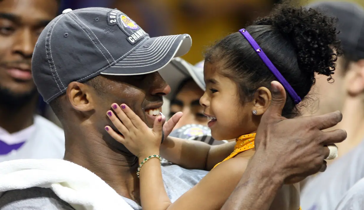 Pebasket LA Lakers, Kobe Bryant, memeluk putrinya Gianna usai mengalahkan Orlando Magic pada laga NBA di Amway Arena, Orlando, Kamis (14/6/2009). (AP/Stephen M Dowell)