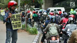 Aktivis Koalisi Pejalan Kaki membawa poster saat aksi peduli pejalan kaki di kawasan pedestrian Kasablanka, Jakarta, Kamis (22/8). Mereka menyerukan agar tidak menggunakan trotoar sebagai tempat parkir dan berjualan.(Liputan6.com/JohanTallo)