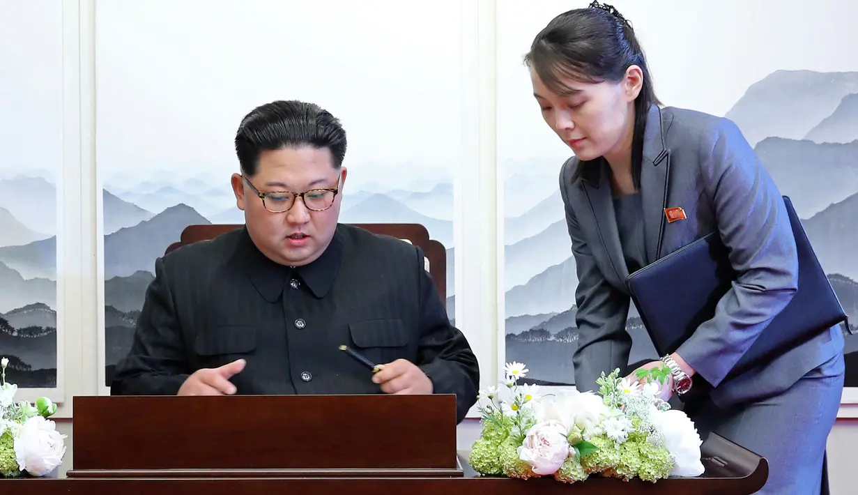 Pemimpin Korea Utara, Kim Jong-un menandatangani buku tamu di Peace House Panmunjom di samping adiknya, Kim Yo Jong sebelum melakukan pertemuan bersejarah dengan Presiden Korea Selatan, Moon Jae-in, Jumat (2/4). (Korea Summit Press Pool via AP)