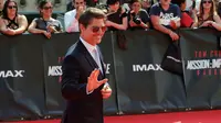 Aktor ganteng, Tom Cruise berpose setibanya di World premiere film terbarunya, Mission: Impossible Fallout di Paris, Kamis (12/7). Film Mission: Impossible 6 ini dipenuhi dengan adegan menentang kematian dan aksi nekat lainnya. (AP/Thibault Camus)