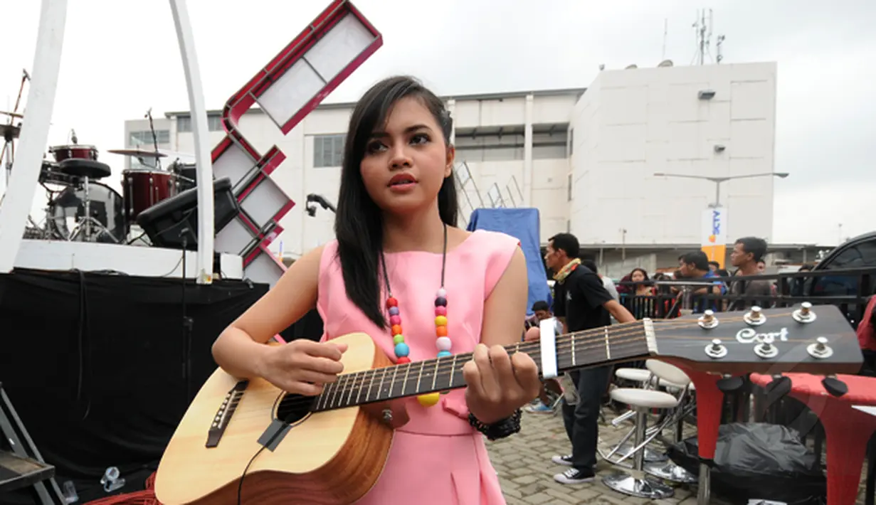 Pemenang keempat ajang Music Vidio Contest, Alif Ekacahya memainkan gitarnya di belakang panggung inBox SCTV yang dihelat di Cibinong, Bogor, Selasa (27/1/2015). (Liputan6.com/Helmi Fithriansyah)