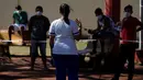 Perawat berbicara kepada warga yang menjalani karantina di sebuah sekolah di Ciudad del Este, Paraguay, Rabu (24/6/2020). Paraguay mengendalikan pandemi COVID-19 dengan hanya beberapa ribu kasus yang dikonfirmasi dan beberapa lusin kematian. (AP Photo/Jorge Saenz)