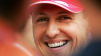 Pembalap Ferrari, Michael Schumacher tersenyum di paddock setelah sesi kualifikasi Formula 1 GP Bahrain di Sirkuit Sakhir pada 11 Maret 2006. (AFP/Loic Venance)