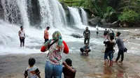 Nampak para pengunjung Curug Dengdeng, Kabupaten Tasikmalaya tengah menikmati semburan air terjun yang jernih dengan pemandangan yang masih asri. (Liputan6.com/Jayadi Supriadin)