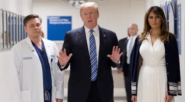 Presiden AS Donald Trump (tengah) didampingi istrinya Melania Trump (kanan) dan dokter Igor Nichiporenko (kiri) saat mengunjungi rumah sakit Broward Health North Pompano Beach, Florida (16/2). (AFP Photo/Jim Watson)