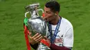 Striker Portugal, Cristiano Ronaldo, mencium trofi juara Piala Eropa 2016, Senin (11/7/2016) dini hari WIB. (AFP/Miguel Medina)