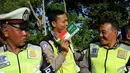 Ekspresi Polisi saat mendapatkan stiker bendera Indonesia dan Arab Saudi selama persiapan menyambut Raja Arab Saudi Salman bin Abdulaziz,Nusa Dua, Bali (2/3). (AFP Photo / Sonny Tumbelaka)