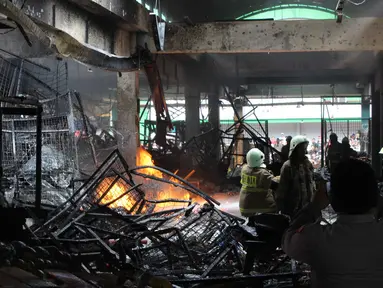 Personel dari Dinas Penanggulangan Kebakaran dan Penyelamatan DKI Jakarta berupaya memadamkan api yang membakar Pasar Induk Kramat Jati pada Senin (15/12/2025). Kebakaran hebat terjadi di Pasar Induk Kramat Jati, Jakarta Timur. Titik api diketahui berada di kios buah. (merdeka.com/magang/Rendi Saputra)