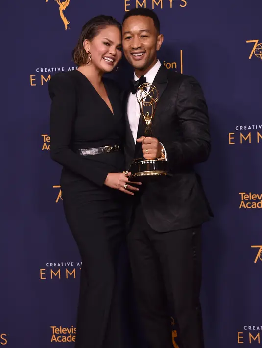 Chrissy Teigen dan John Legend berpose selama Creative Arts Emmy di Los Angeles, California, (9/9). Penghargaan ini untuk artis yang telah memenangkan di Emmy, Grammy, Oscar, dan Tonys. (AFP Photo/Alberto E. Rodriguez)