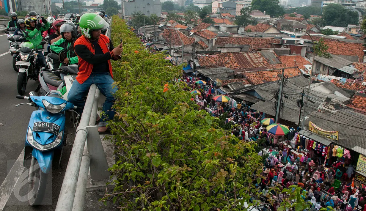 Warga mengabadikan suasana di kawasan Tanah Abang, Jakarta, Kamis (11/5). PKL memanfaatkan Libur Waisak untuk kembali berdagang kembali di trotoar sehingga menyebabkan kemacetan. (Liputan6.com/Gempur M Surya)