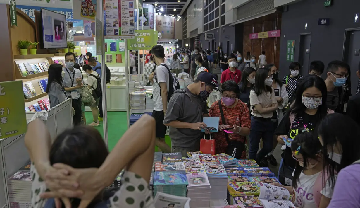 <p>Pengunjung membaca di stan selama pameran buku tahunan di Hong Kong, Rabu (20/7/2022). Pameran Buku Hong Kong akan diadakan pada 20-26 Juli. (AP Photo/Kin Cheung)</p>