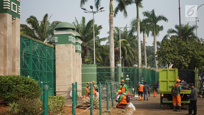 Petugas mengangkut sampah sisa bentrok antara mahasiswa dan polisi dalam unjuk rasa di depan Gedung DPR RI, Jakarta, Rabu (25/9/2019). Bentrokan pada Selasa (24/9/2019) menyisakan sampah yang memenuhi kawasan di sekitar Gedung DPR. (Liputan6.com/Immanuel Antonius)
