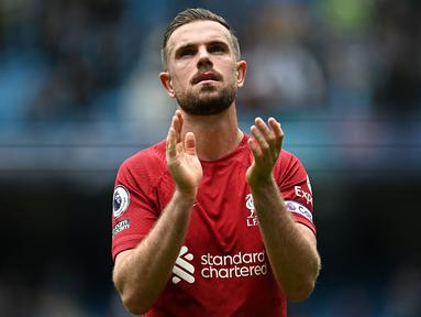 Pemain Liverpool, Jordan Henderson memberikan tepuk tangan setelah laga lanjutan Liga Inggris 2022/2023 melawan Manchester City di Etihad Stadium, Manchester, 1 April 2023. Henderson mengalami penurunan performa pada musim lalu. Ia kesulitan menopang lini serang sekaligus lini pertahanan Liverpool di sisi kanan. Alhasil, pria Inggris tersebut tak selalu dipilih oleh Jurgen Klopp sebagai starter. Henderson harus bekerja ekstra sebab posisinya terancam oleh detangan Dominik Szoboszlai. (AFP/Paul Ellis)