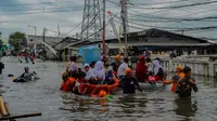 Sejumlah pelajar menggunakan perahu Badan Penanggulangan Bencana Daerah (BPBD) Jakarta untuk melintasi banjir pesisir atau rob di kawasan Muara Angke, Jakarta, Senin (16/12/2024). (merdeka.com/Arie Basuki)