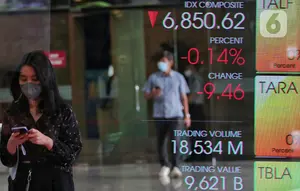 Karyawan melintasi layar yang menampilkan Indeks Harga Saham Gabungan (IHSG) saat acara Penutupan Perdagangan Bursa Efek Indonesia Tahun 2022 di Jakarta, Jumat (30/12/2022). PT Bursa Efek Indonesia (BEI) mencatat ada 59 perusahaan yang melakukan Initial Public Offering (IPO) atau pencatatan saham sepanjang 2022. Pada penutupan perdagangan akhir tahun, Indeks Harga Saham Gabungan (IHSG) ditutup lesu 0,14% atau 9,46 poin menjadi 6.850,62. (Liputan6.com/Angga Yuniar)