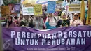 Puluhan massa aksi yang tergabung dalam beberapa aktivis wanita membawa spanduk saat menggelar aksi unjuk rasa dikawasan Patung Kuda, Jakarta, Rabu (8/3). (Liputan6.com/Faizal Fanani)
