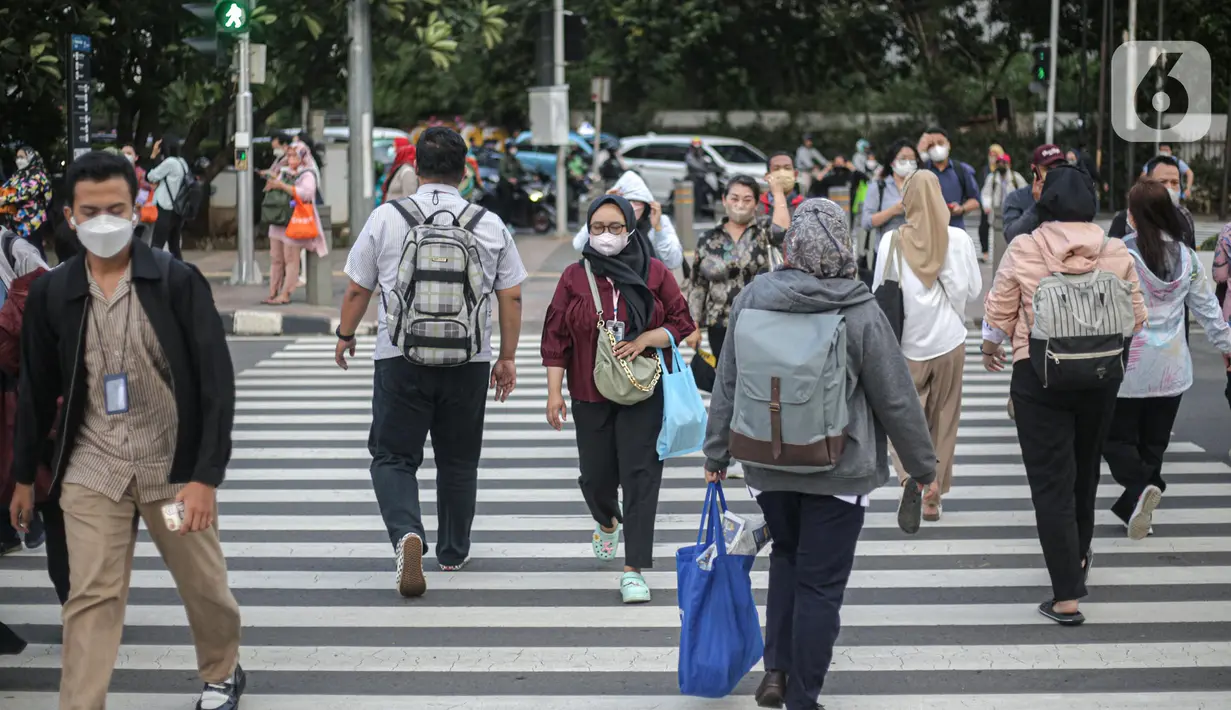 Pekerja kantoran melintas di pelican cross kawasan Jalan Thamrin, Jakarta, Kamis (5/1/2023). Pencabutan Pemberlakuan Pembatasan Kegiatan Masyarakat (PPKM) dinilai untuk menggenjot ekonomi Indonesia 2023 yang diproyeksi suram akibat resesi global. (Liputan6.com/Faizal Fanani)