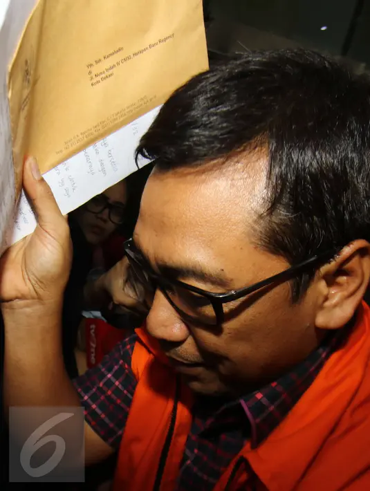 Tersangka dugaan suap uji materiil Undang-Undang Peternakan dan Kesehatan, Kamaludin menghindari wartawan yang akan meliputnya usai menjalani pemeriksaan di gedung KPK, Jakarta, Kamis  (2/2). (Liputan6.com/Helmi Afandi) 