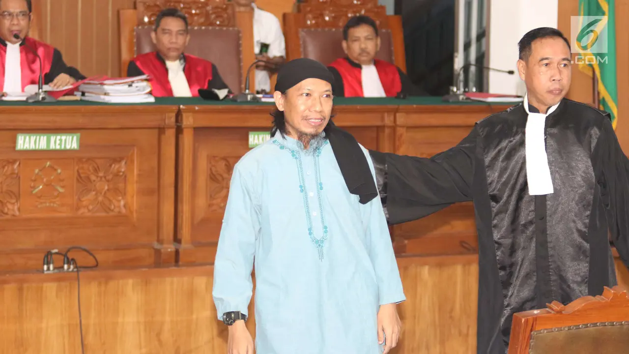 Terdakwa kasus teror bom Thamrin, Aman Abdurrahman bersiap menjalani sidang pembacaan vonis di Pengadilan Negeri Jakarta Selatan, Jumat (22/6). Aman Abdurrahman hadir dengan pengawalan ketat satuan kepolisian bersenjata lengkap (Liputan6.com/Angga Yuniar)