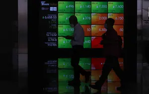 Pekerja melintas di depan layar Indeks Harga Saham Gabungan (IHSG) di BEI, Jakarta, Senin (3/1/2022). Pada pembukan perdagagangan bursa saham 2022 Indeks Harga Saham Gabungan (IHSG) langsung menguat 7,0 poin atau 0,11% di level Rp6.588,57. (Liputan6.com/Angga Yuniar)