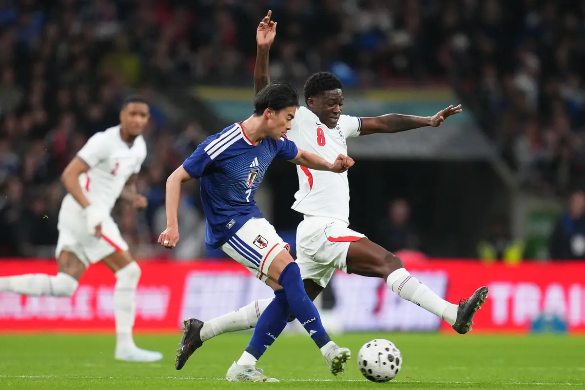 Winger Timnas Jepang Kaoru Mitoma diadang gelandang Timnas Inggris Kobbie Mainoo di laga uji coba di Stadion Wembley, Rabu (01/4/2026) dini hari WIB.