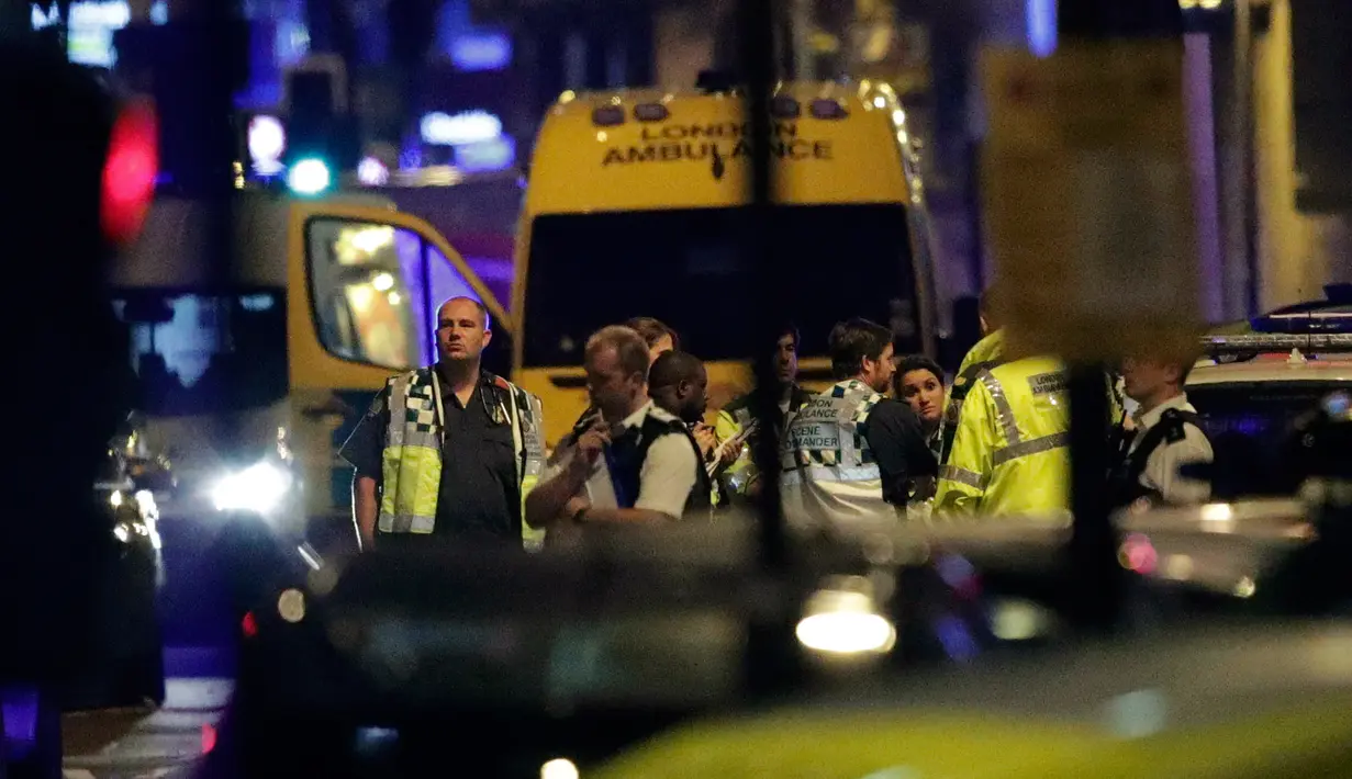 Petugas medis menunggu untuk memberikan bantuan usai sebuah kendaraan menabrak pejalan kaki di kawasan Finsbury Park, utara London, Senin (19/6). Polisi menyebut sebuah van menabrak kerumunan orang di dekat masjid Finsbury Park (Yui Mok/PA via AP)