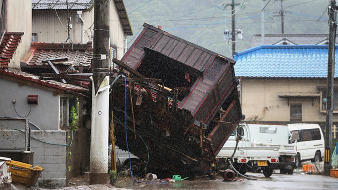 Kerangka bangunan tersapu banjir yang disebabkan hujan lebat di sebuah jalan di Hitoyoshi, prefektur Kumamoto, Jepang, Minggu (5/7/2020). Banjir di wilayah Kumamoto yang memicu tanah longsor ini telah menghancurkan ratusan rumah dan kendaraan serta membuat jembatan terputus. (STR/JIJI PRESS/AFP)