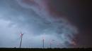 Badai awan gelap terlihat di langit di atas turbin angin di Sieversdorf, Jerman (10/6/2019). (AFP Photo/dpa/Germany Out/Patrick Pleul)