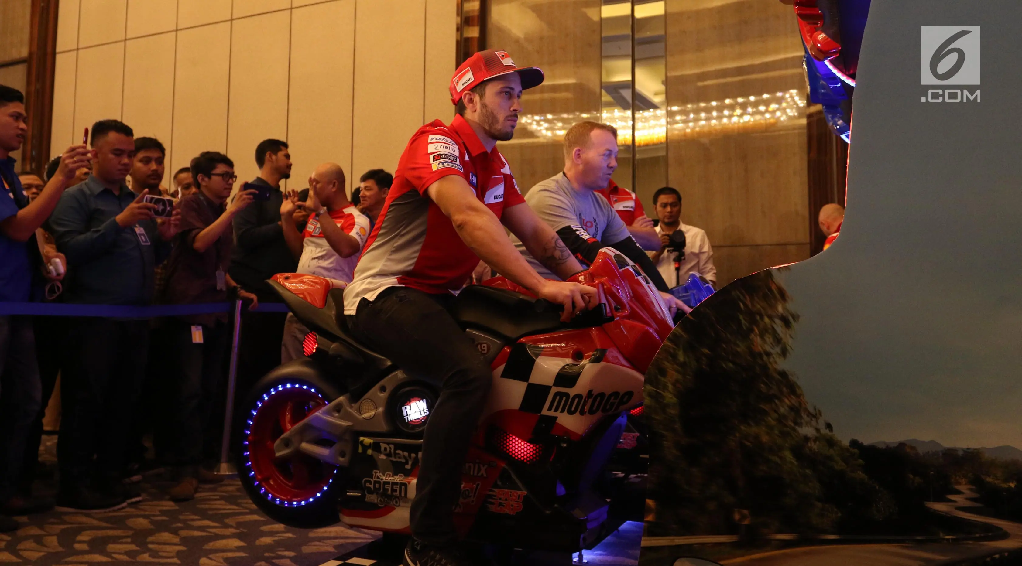 Pembalap MotoGP Andrea Dovizioso memainkan game motor balap saat mengkampanyekan Libas Tantanganmu di Jakarta, Kamis (1/2). (Liputan6.com/Angga Yuniar)