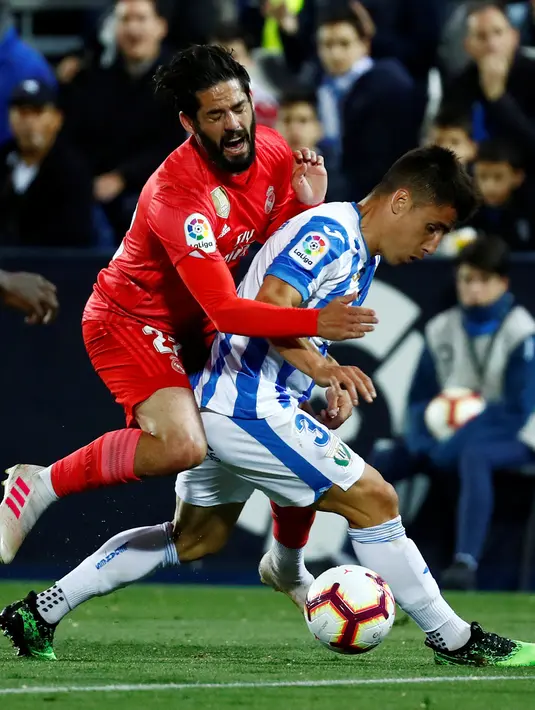 Gelandang Real Madrid, Isco Alarcon berebut bola dengan  pemain Leganes, Unai Bustinza dalam lanjutan La Liga 2018-2019 di Estadio Municipal Butarque, Senin (15/4). Real Madrid hanya mampu meraih hasil imbang 1-1 saat bertandang ke markas Leganes. (REUTERS/Juan Medina)