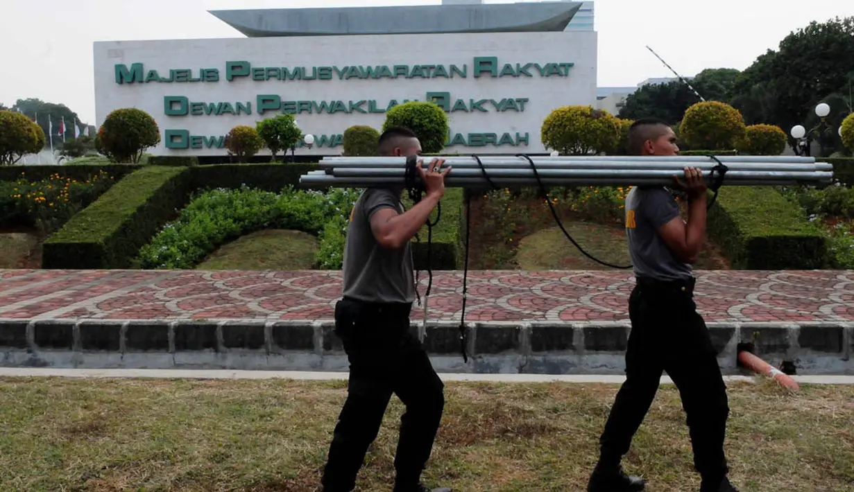 Personel kepolisian bergotong-royong memasang tenda sebagai persiapan pengamanan pelantikan Jokowi-JK sebagai presiden dan wakil presiden di gedung parlemen tersebut, Jakarta, (15/10/14). (Liputan6.com/Andrian M Tunay)