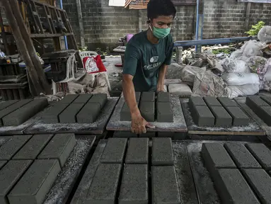 Pekerja menyelesaikan pembuatan paving block berbahan sampah plastik di Rebricks, Pondok Pinang, Jakarta, Kamis (29/10/2020). Rebricks menyasar sampah plastik sebagai salah satu material utama pembuatan paving block dengan harga jual Rp 95.000 per meter persegi. (Liputan6.com/Johan Tallo)