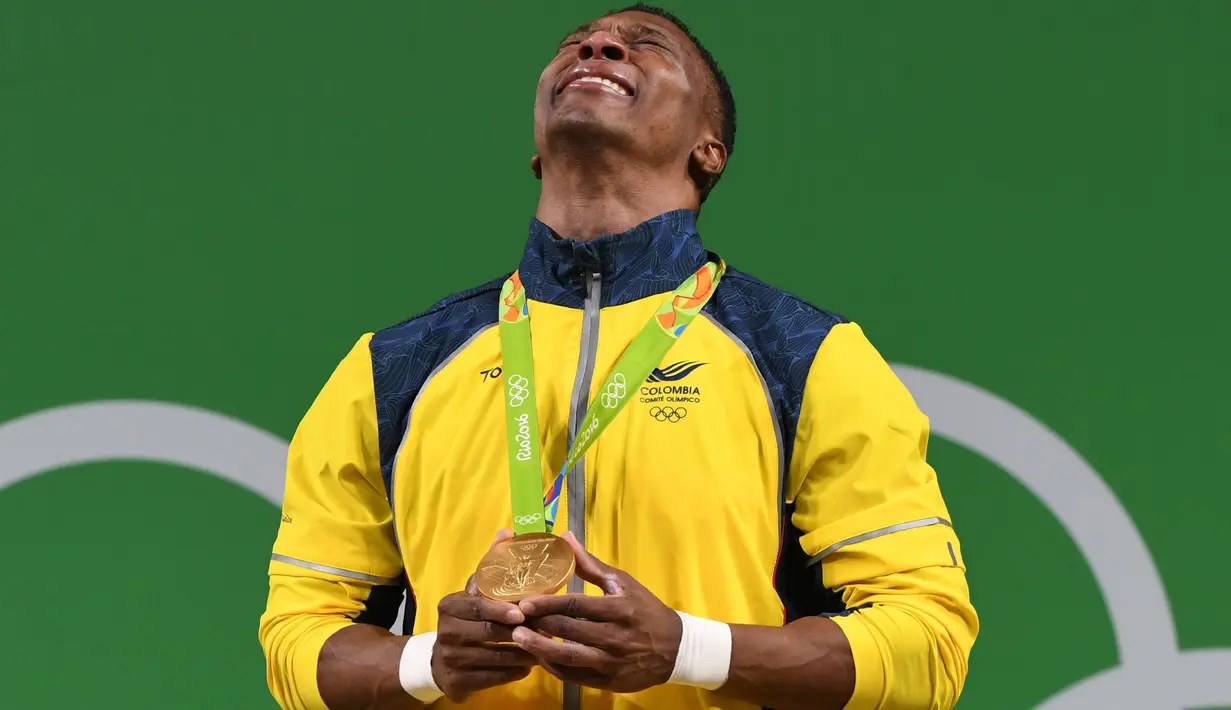 Atlet angkat besi Kolombia, Oscar Figueroa menitikkan air mata setelah sukses merebut medali emas terakhir sebelum pensiun dari cabang olahraga angkat besi di kelas 62 kg di Olimpiade Rio 2016, 8 Agustus 2016. (AFP PHOTO/GOH Chai Hin)